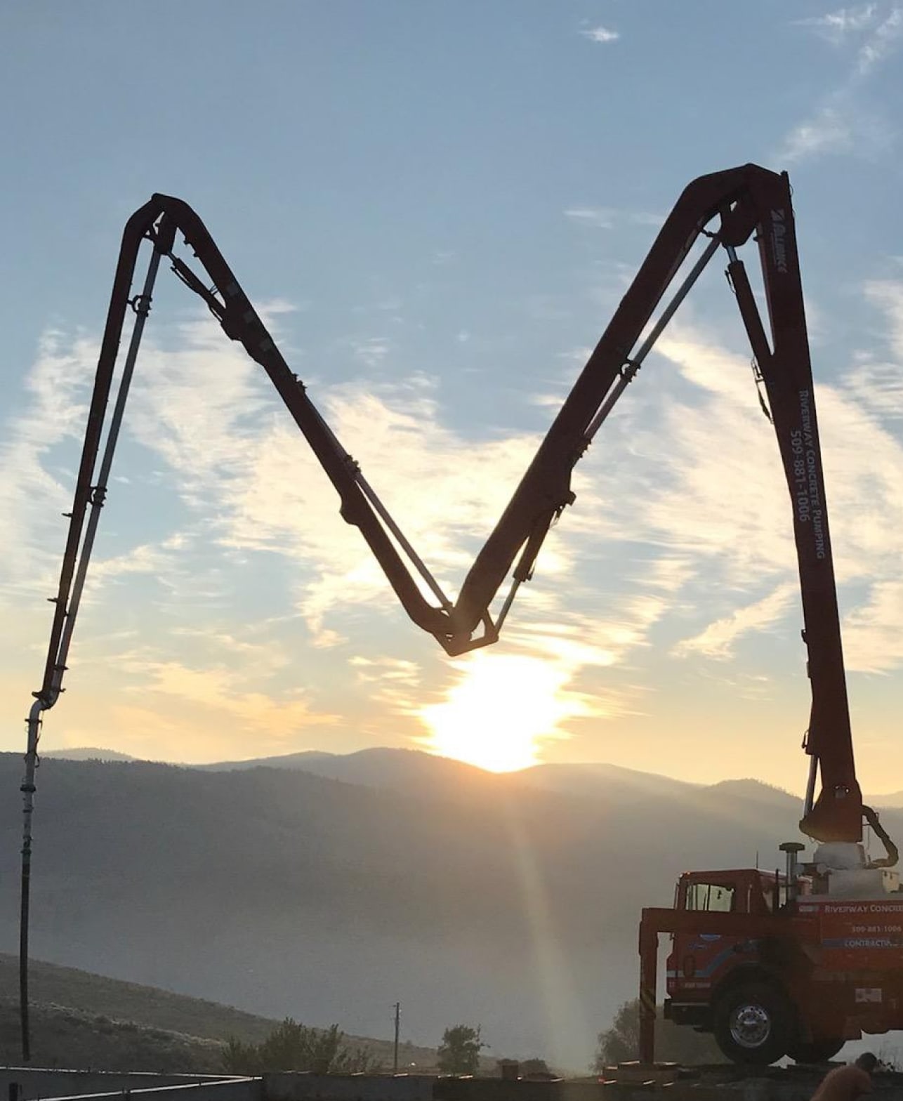 Concrete pump in Wenatchee in front of a rising sun